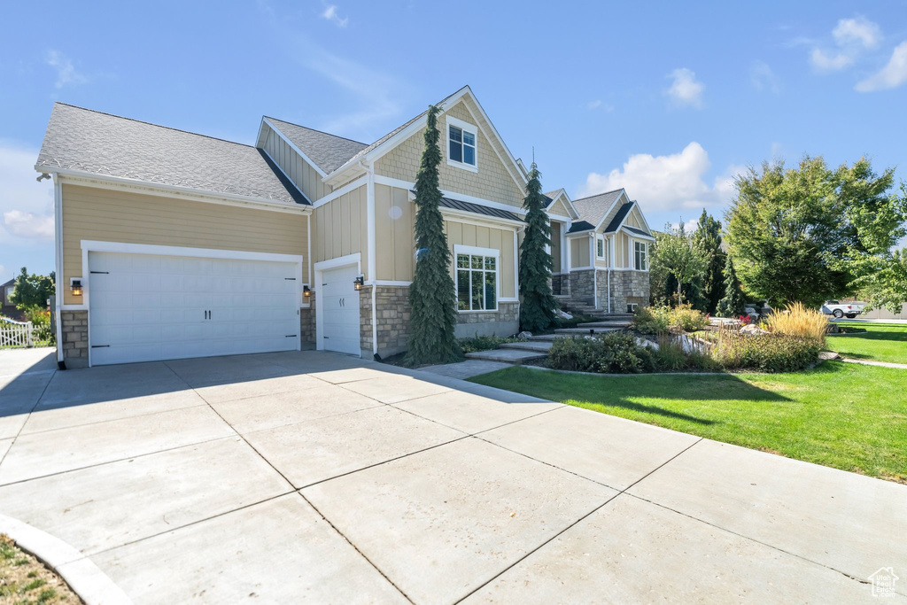 Craftsman-style house with a garage and a front lawn