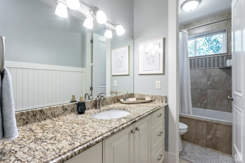 Full bathroom with vanity, toilet, and shower / bathtub combination with curtain