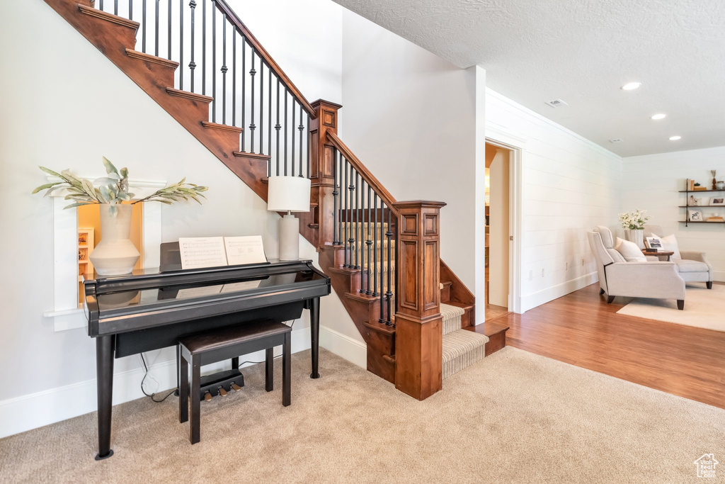 Miscellaneous room with light wood-type flooring, crown molding, and a textured ceiling