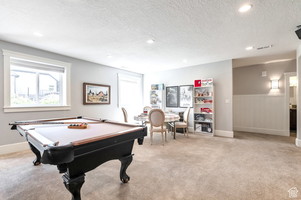 Recreation room featuring a textured ceiling, light colored carpet, and billiards