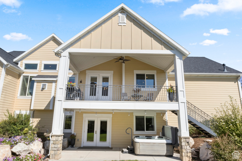 Back of property featuring ceiling fan, french doors, and a hot tub