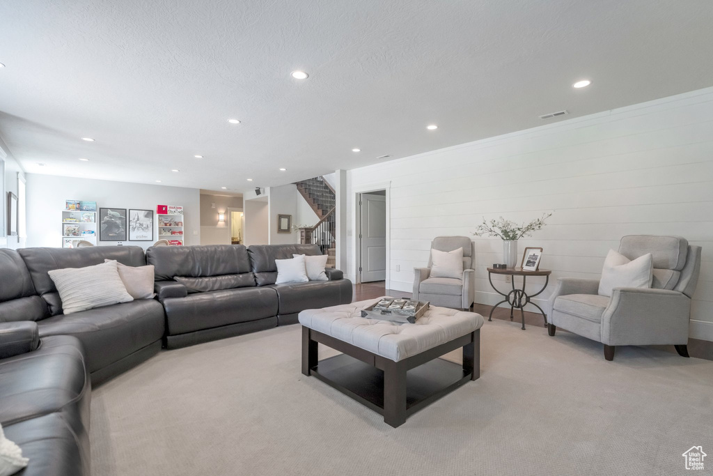 Living room with light carpet, a textured ceiling, and crown molding