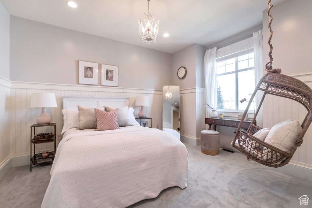 Carpeted bedroom with an inviting chandelier