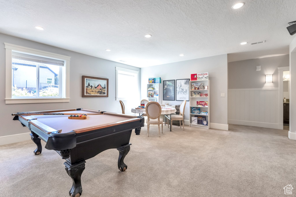 Recreation room with pool table, a textured ceiling, and light colored carpet