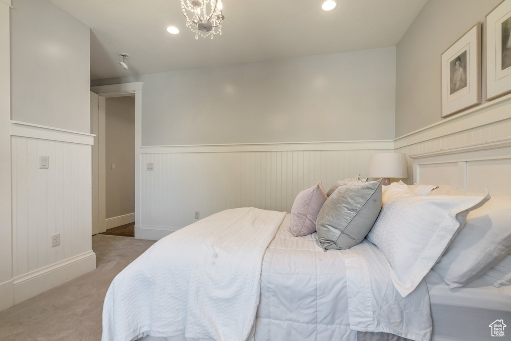 Carpeted bedroom with an inviting chandelier