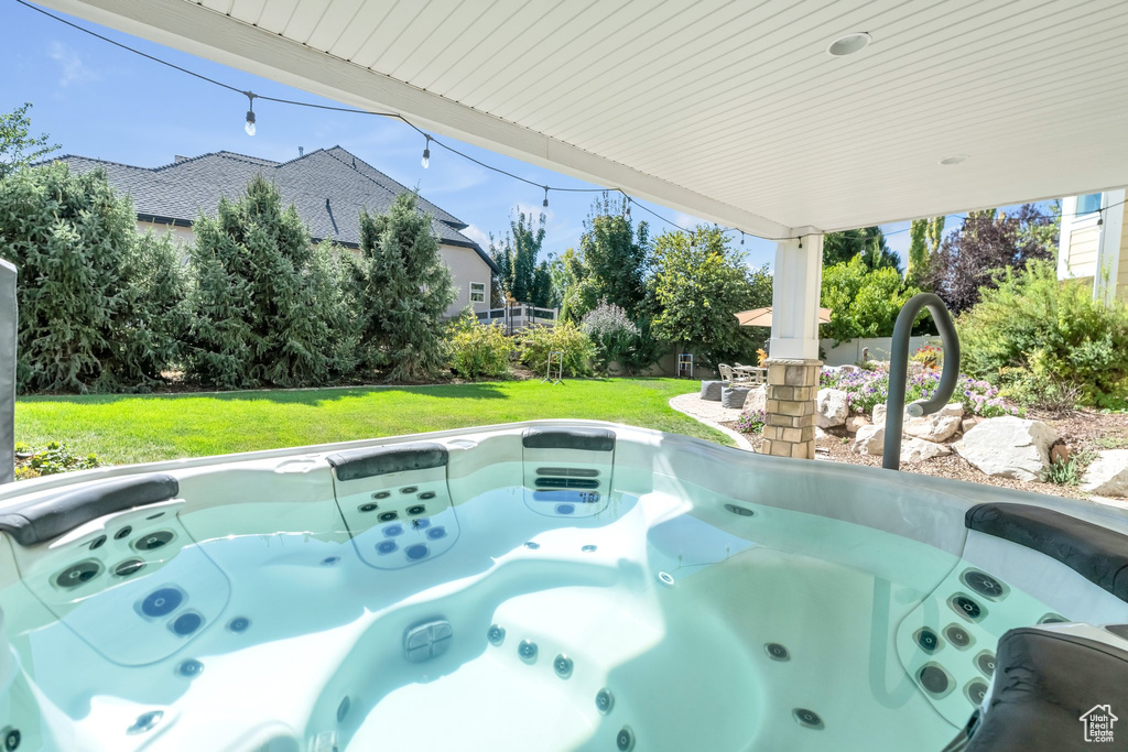 View of pool featuring a yard and a hot tub