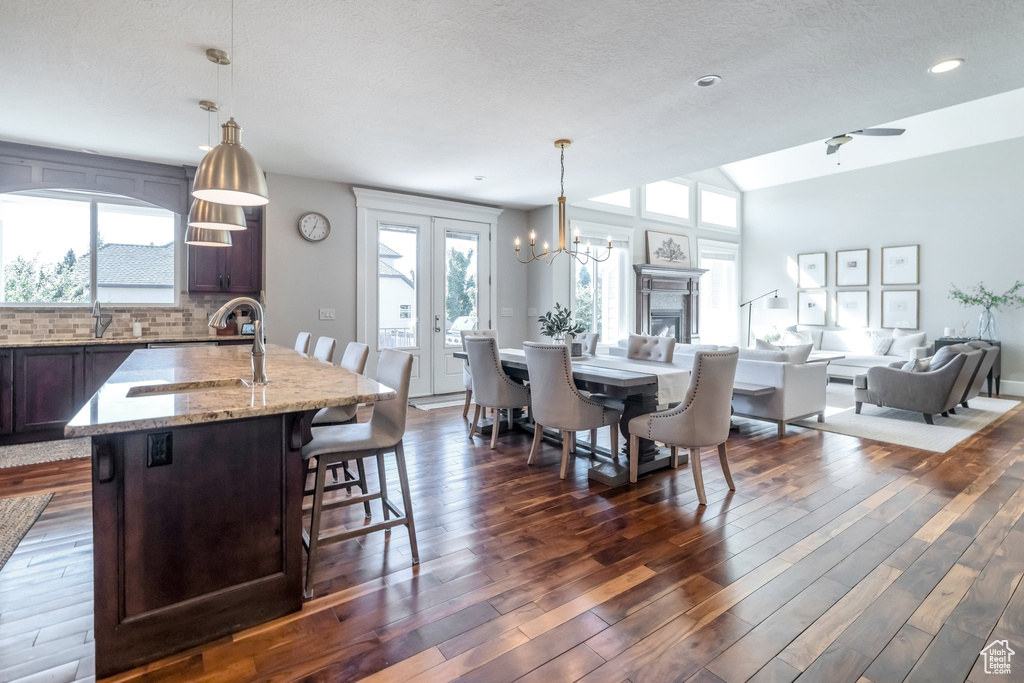 Interior space with sink, ceiling fan with notable chandelier, dark hardwood / wood-style flooring, and a textured ceiling