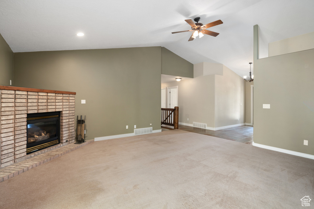 Unfurnished living room with high vaulted ceiling, carpet, ceiling fan, and a fireplace