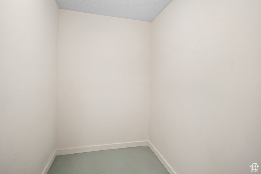 Unfurnished room with a textured ceiling and concrete floors