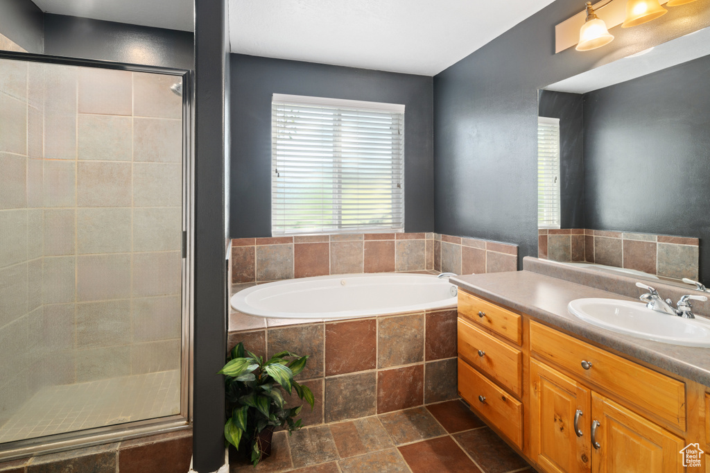 Bathroom featuring vanity and separate shower and tub