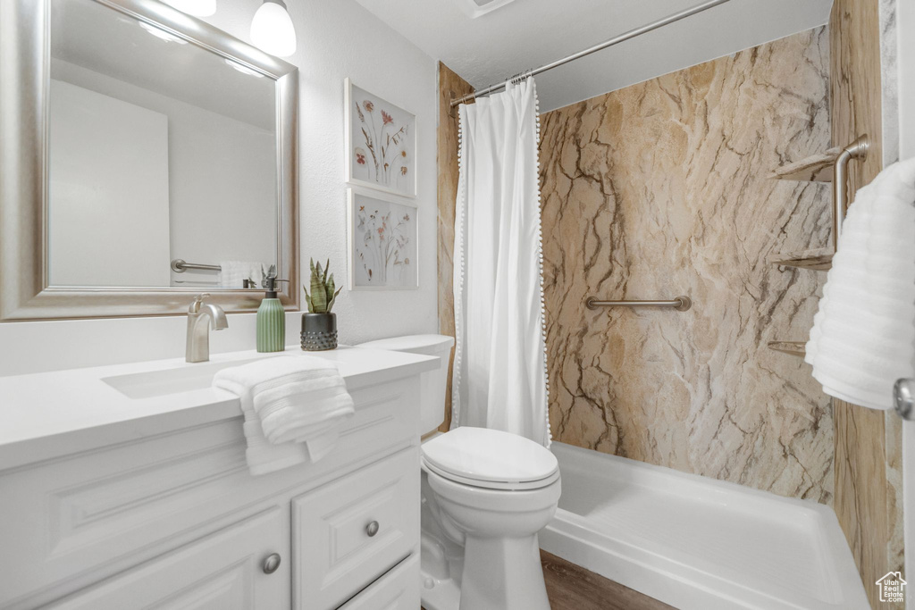 Bathroom featuring walk in shower, vanity, toilet, and wood-type flooring