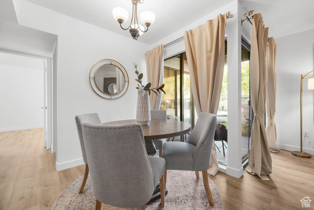 Dining area featuring light hardwood / wood-style flooring and an inviting chandelier