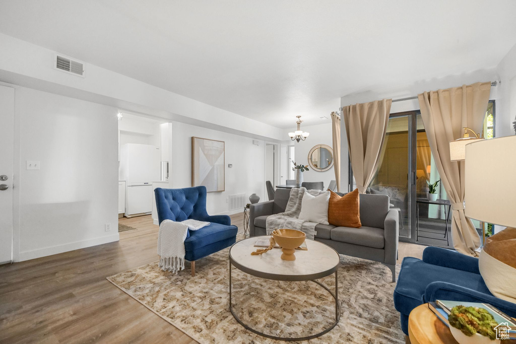 Living room with an inviting chandelier and hardwood / wood-style floors