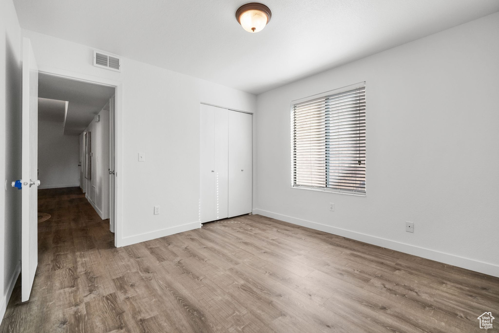 Unfurnished bedroom with light hardwood / wood-style flooring and a closet