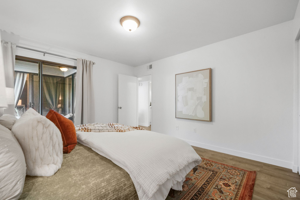 Bedroom with access to exterior and dark wood-type flooring