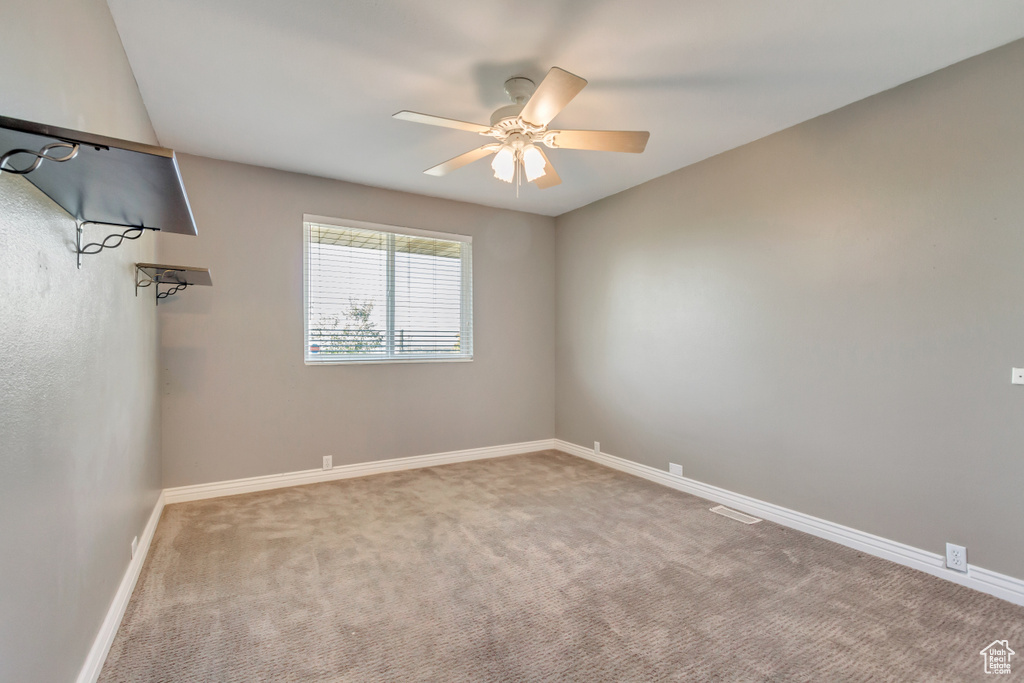 Empty room with carpet and ceiling fan