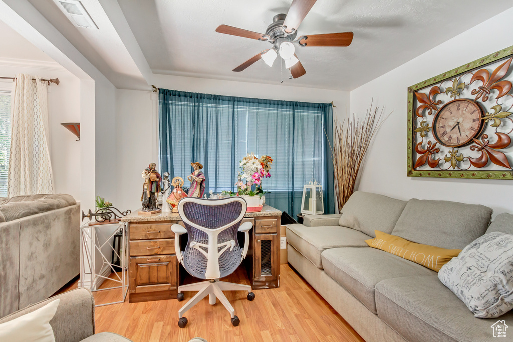 Office with light hardwood / wood-style floors and ceiling fan