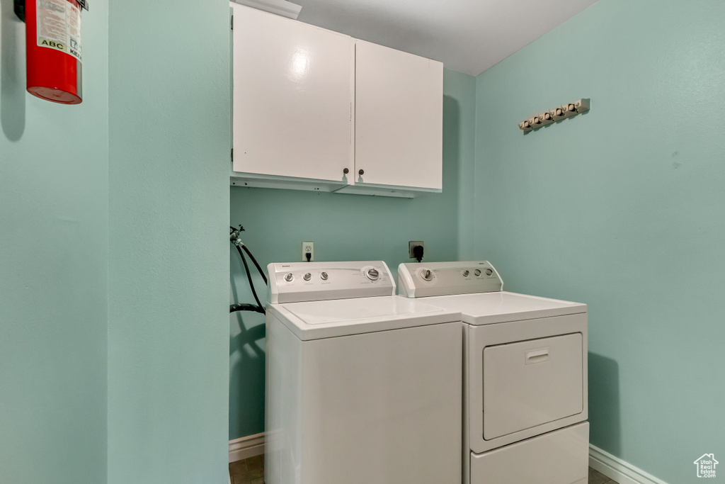 Laundry area featuring washer and clothes dryer and cabinets