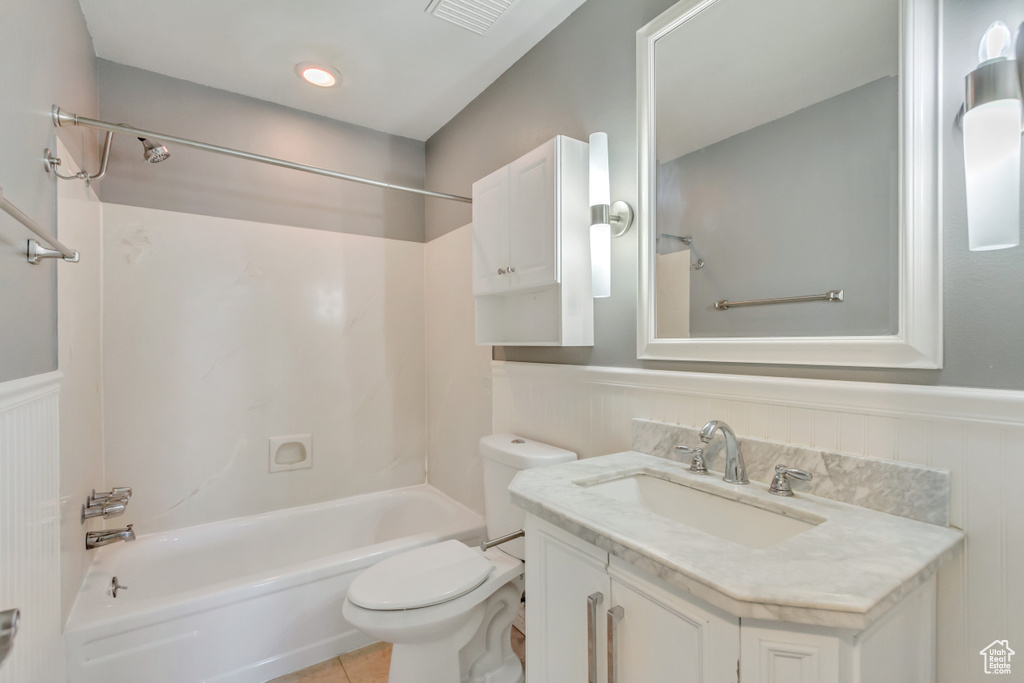 Full bathroom featuring tile patterned flooring, vanity, toilet, and  shower combination