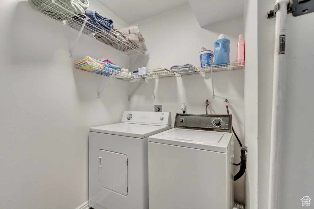 Laundry area with gas water heater and independent washer and dryer