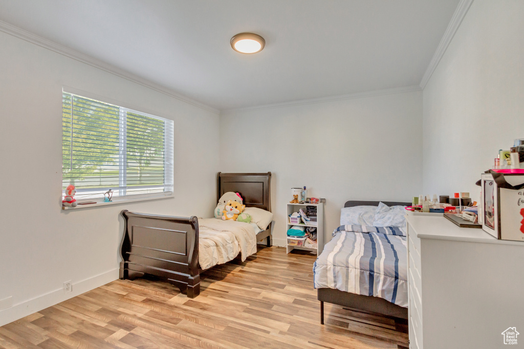 Bedroom with light wood-type flooring and ornamental molding