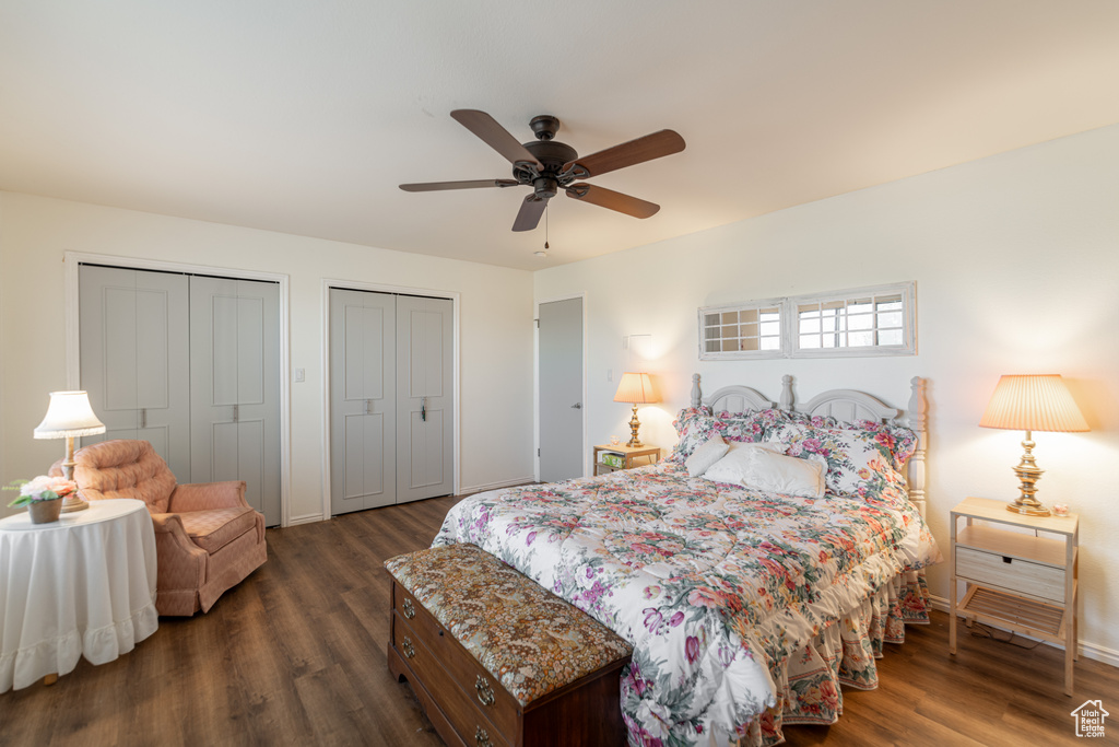 Bedroom featuring ceiling fan, multiple closets, and dark hardwood / wood-style flooring