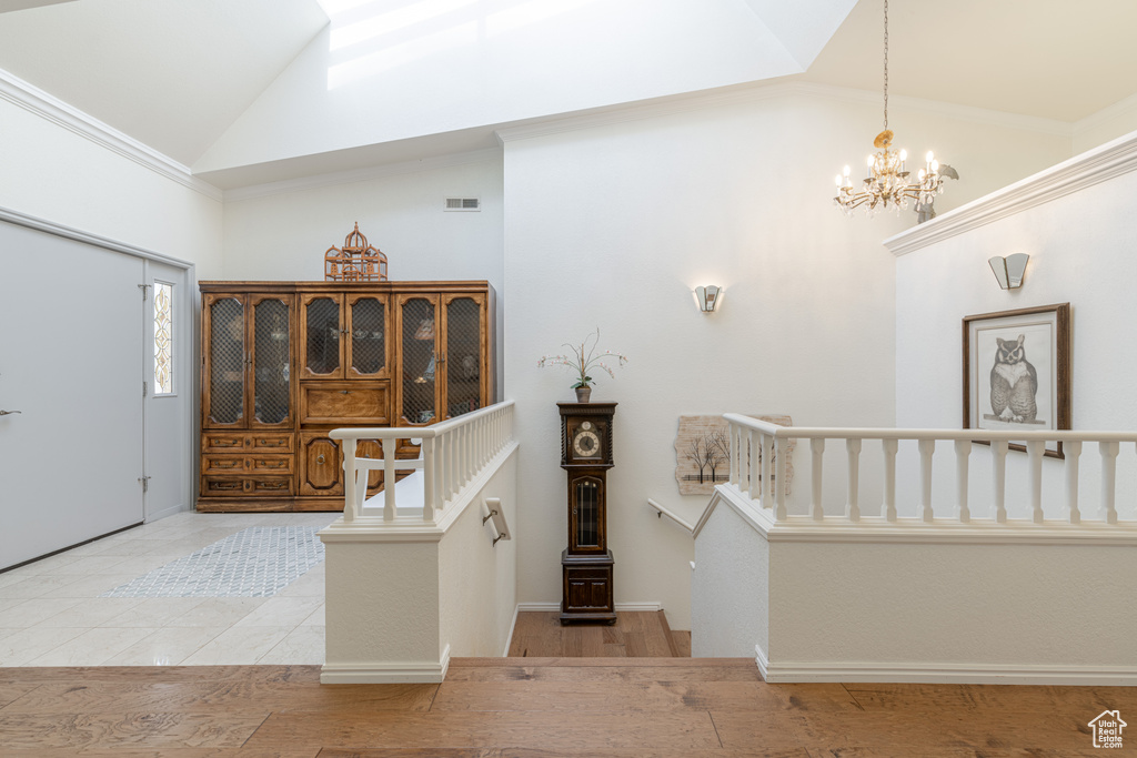 Foyer entrance featuring a notable chandelier, light hardwood / wood-style floors, and high vaulted ceiling