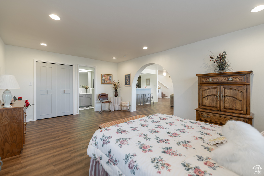 Bedroom with dark hardwood / wood-style flooring and a closet