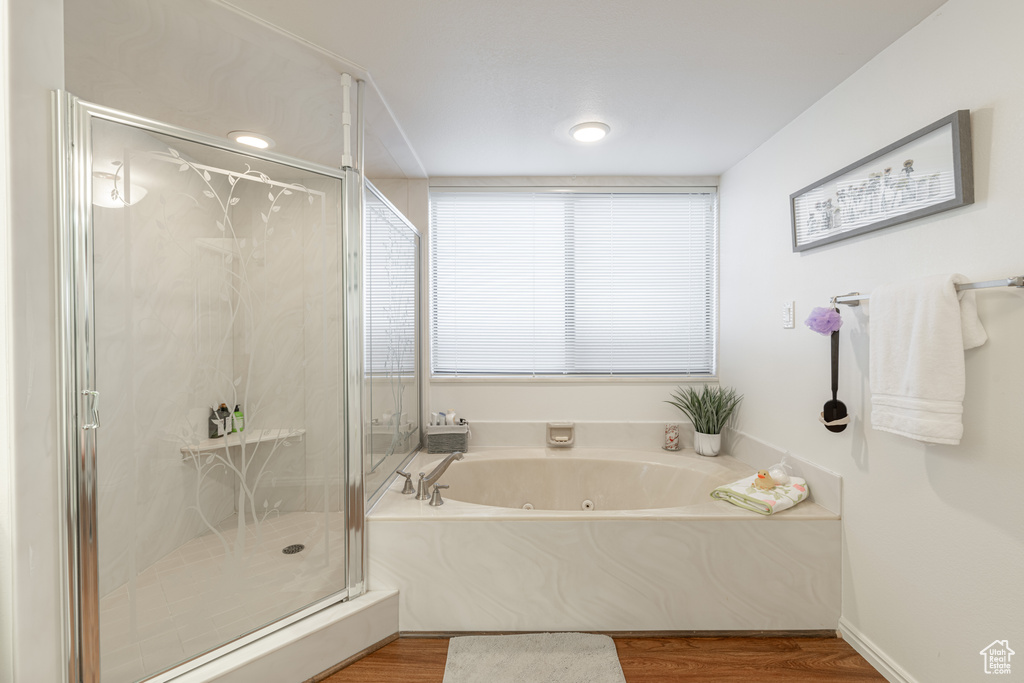 Bathroom featuring hardwood / wood-style flooring and plus walk in shower