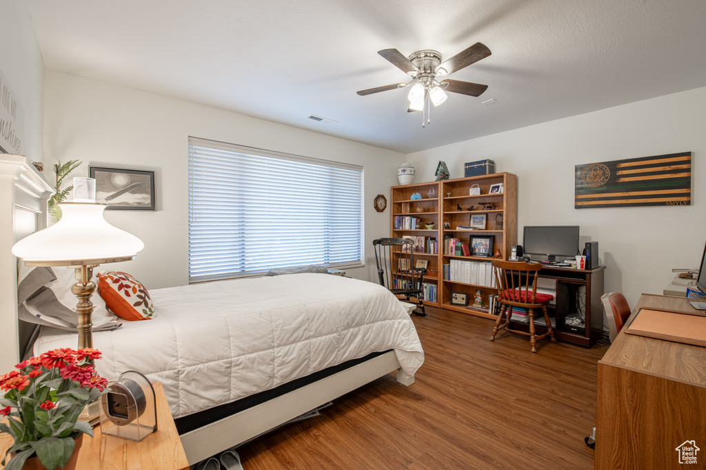 Bedroom with ceiling fan and hardwood / wood-style flooring