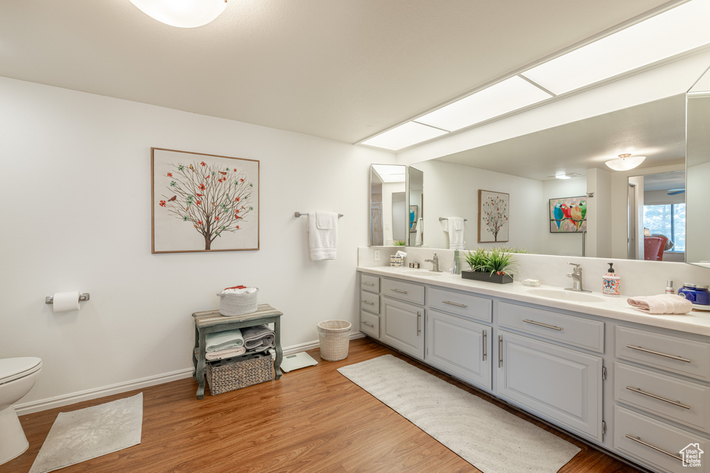 Bathroom featuring hardwood / wood-style floors, vanity, and toilet