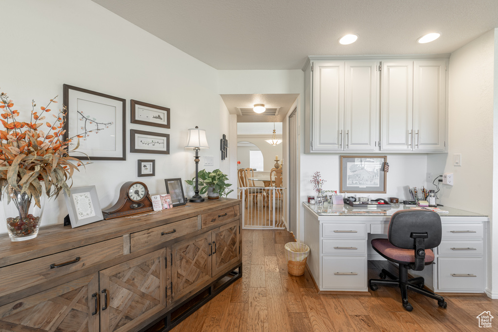 Office area featuring light wood-type flooring and built in desk