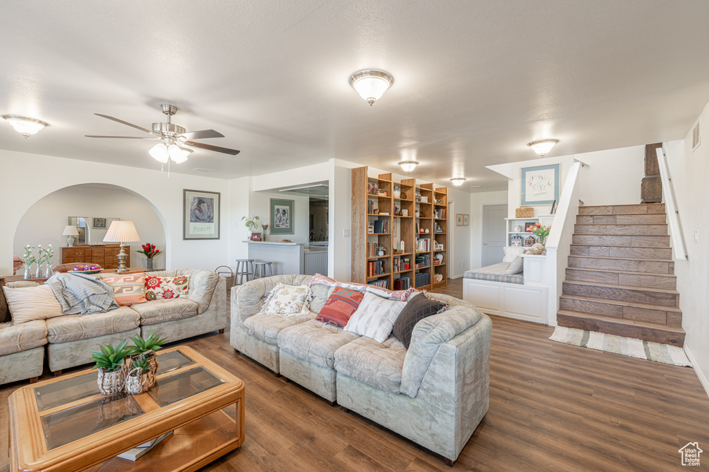 Living room with dark hardwood / wood-style flooring and ceiling fan