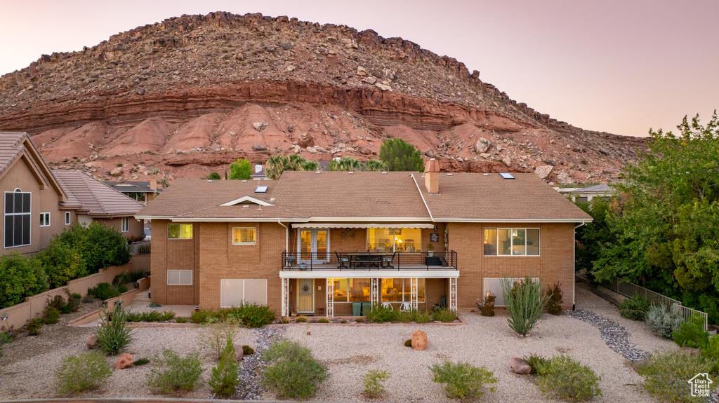 Back house at dusk with a balcony and a mountain view