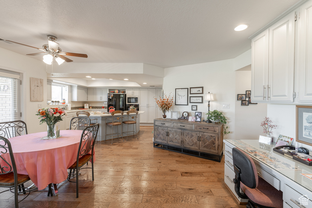 Dining area with light hardwood / wood-style floors and ceiling fan