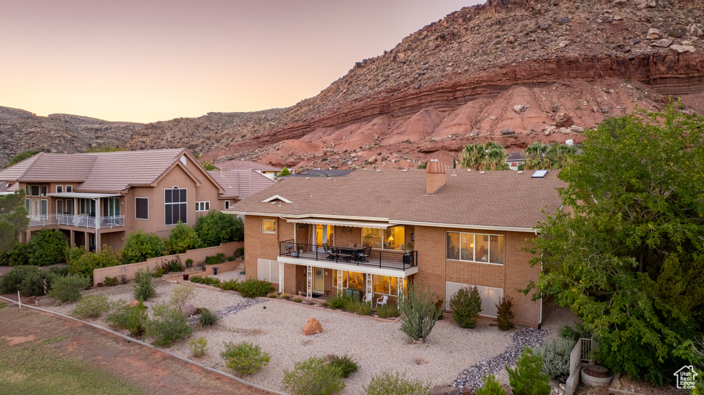 Back house at dusk with a mountain view and a balcony