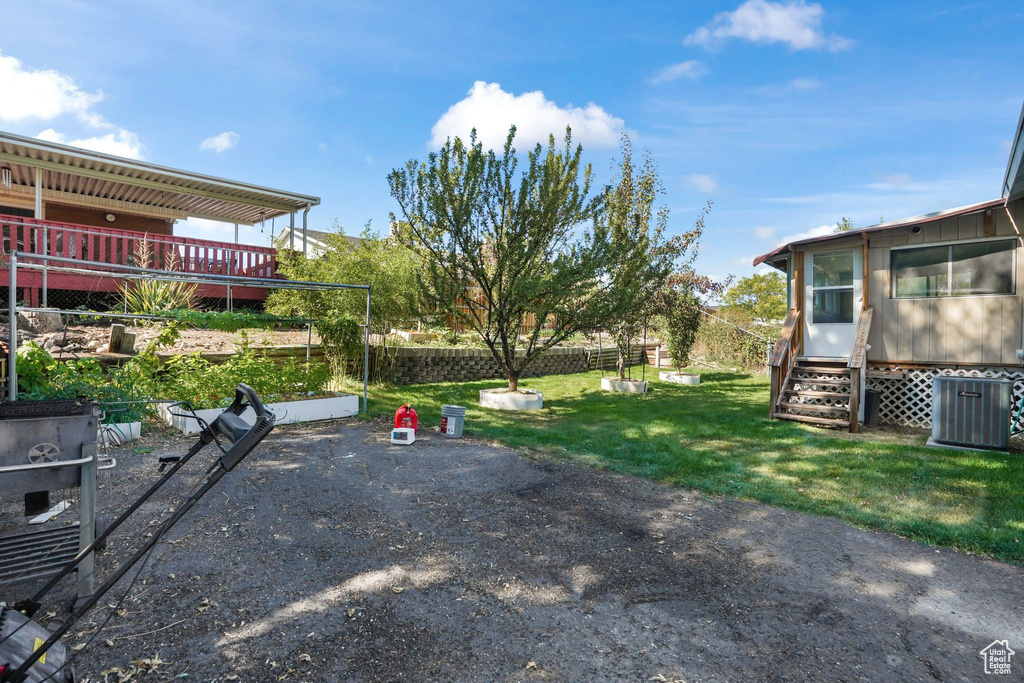 View of yard featuring a wooden deck and central AC