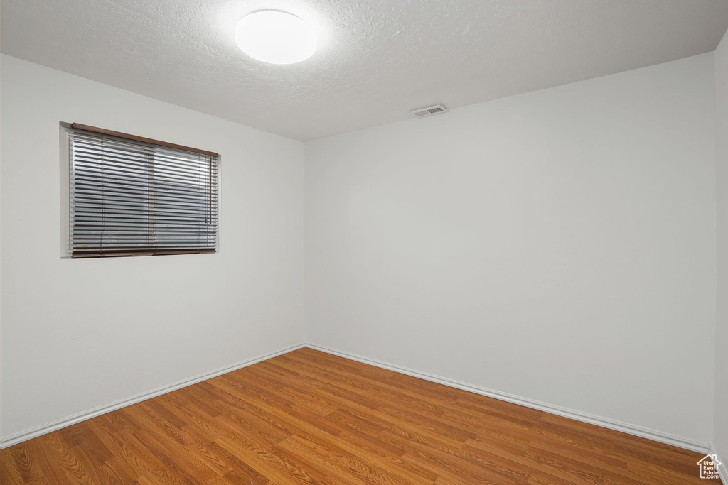 Unfurnished room featuring a textured ceiling and hardwood / wood-style floors