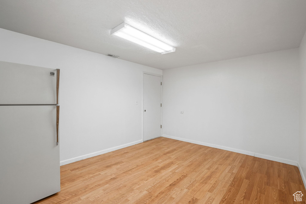 Unfurnished room featuring a textured ceiling and light hardwood / wood-style flooring