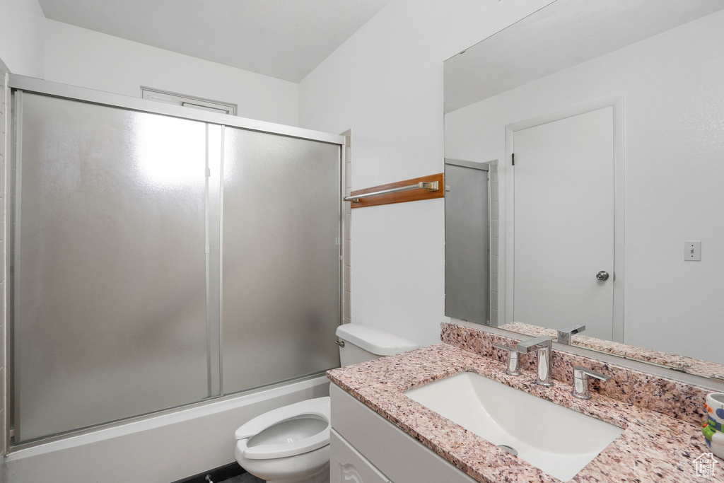 Full bathroom with shower / bath combination with glass door, vanity, and toilet