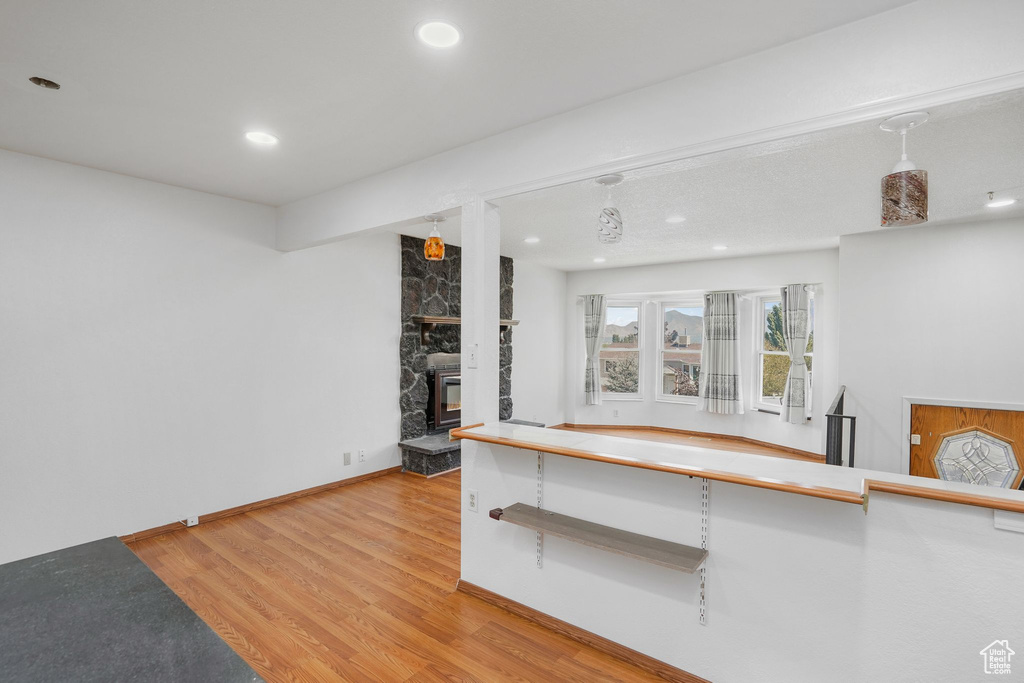 Kitchen with a stone fireplace and hardwood / wood-style floors