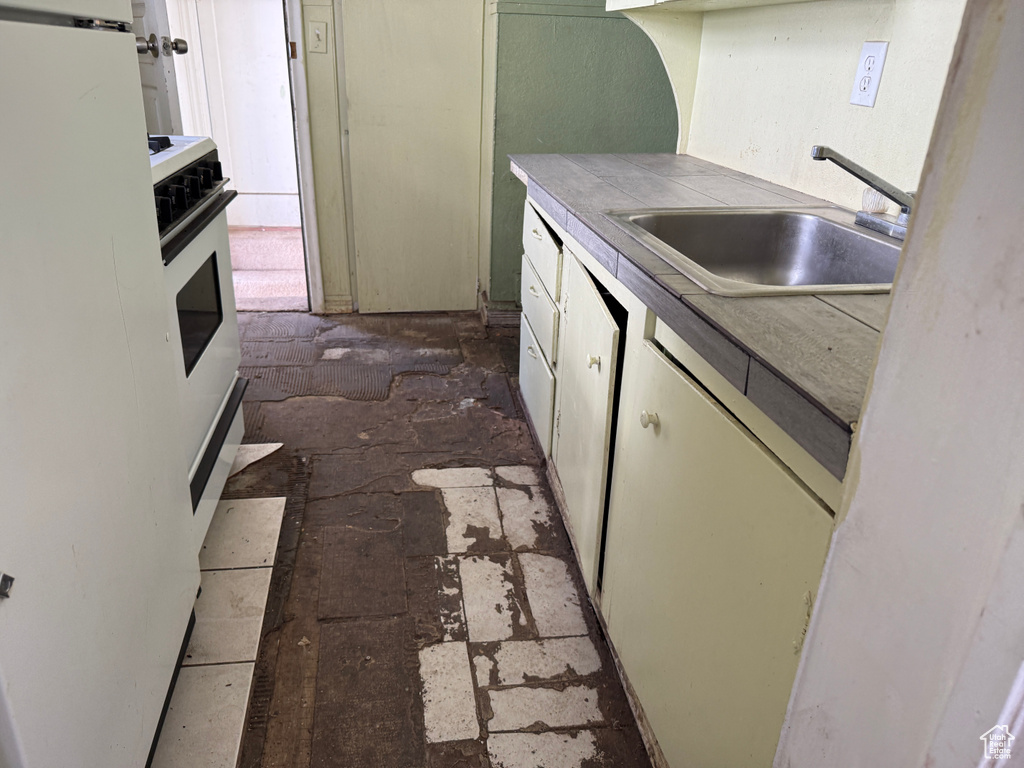 Kitchen featuring oven, tile countertops, and a sink