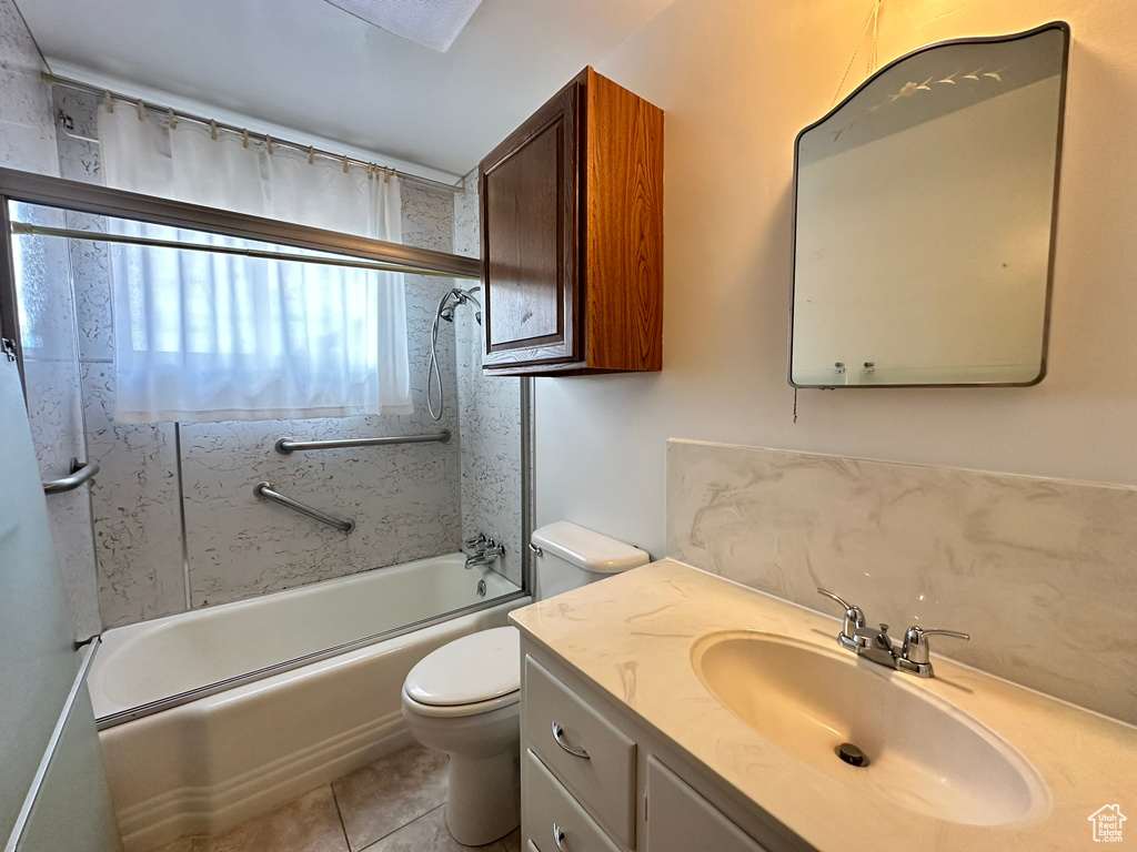 Full bathroom with enclosed tub / shower combo, vanity, tile patterned flooring, and toilet