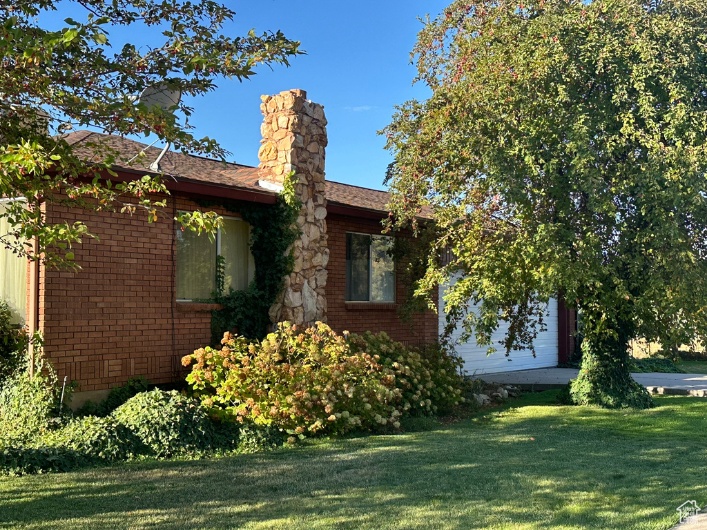 View of side of property with a lawn