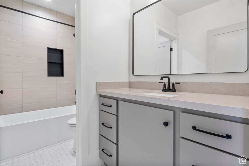 Full bathroom featuring vanity, tiled shower / bath, and toilet