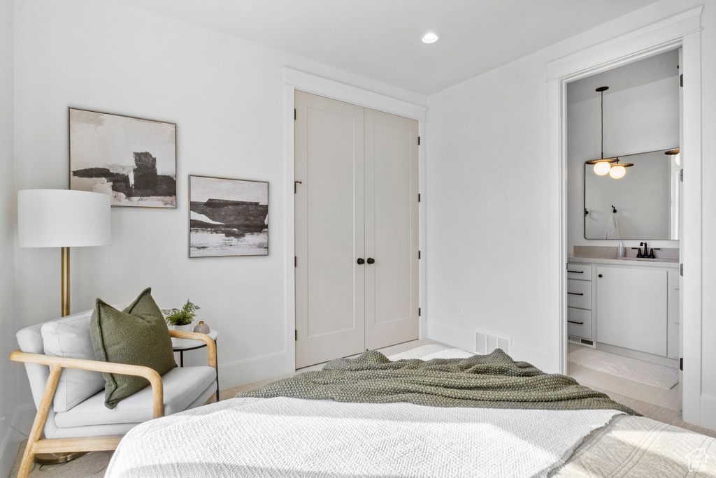 Bedroom with ensuite bath, sink, and a closet