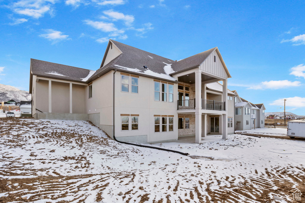 Snow covered property featuring a balcony