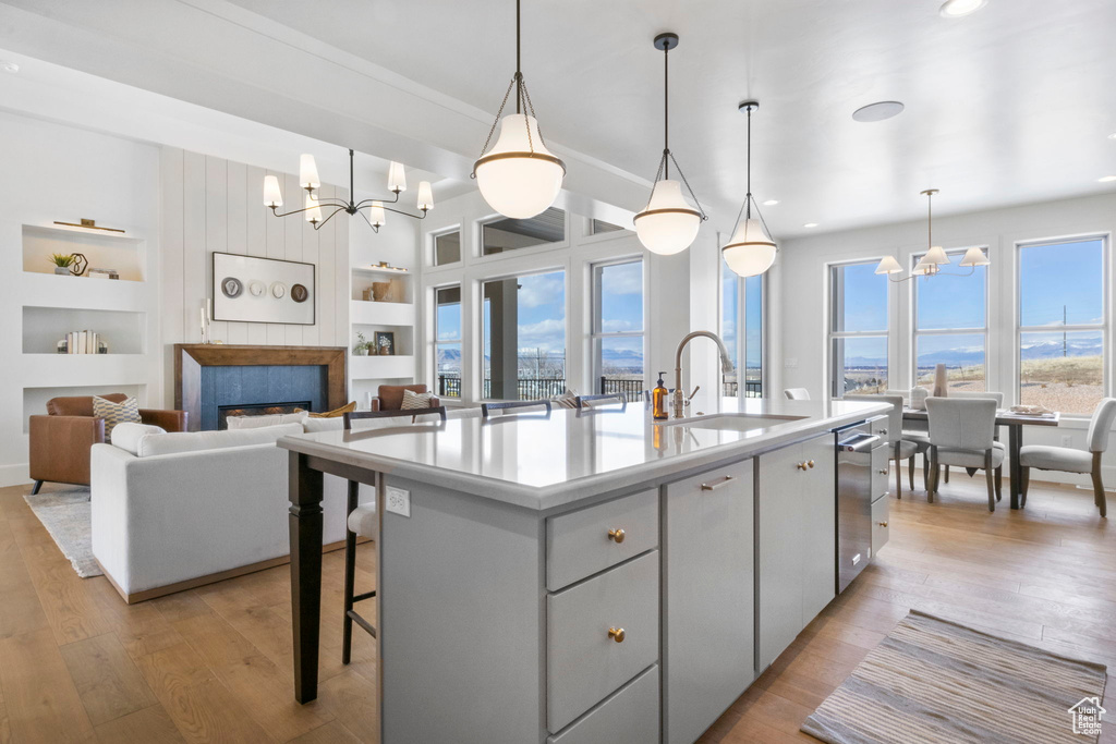 Kitchen with sink, a notable chandelier, decorative light fixtures, and a center island with sink