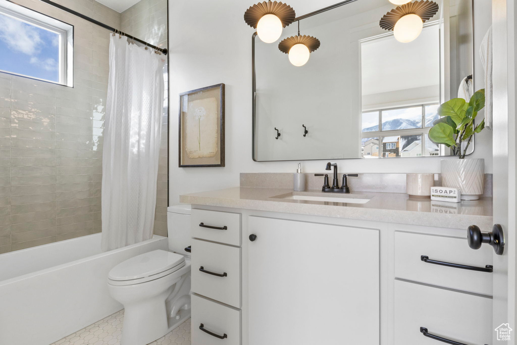 Full bathroom featuring vanity, toilet, and shower / bathtub combination with curtain