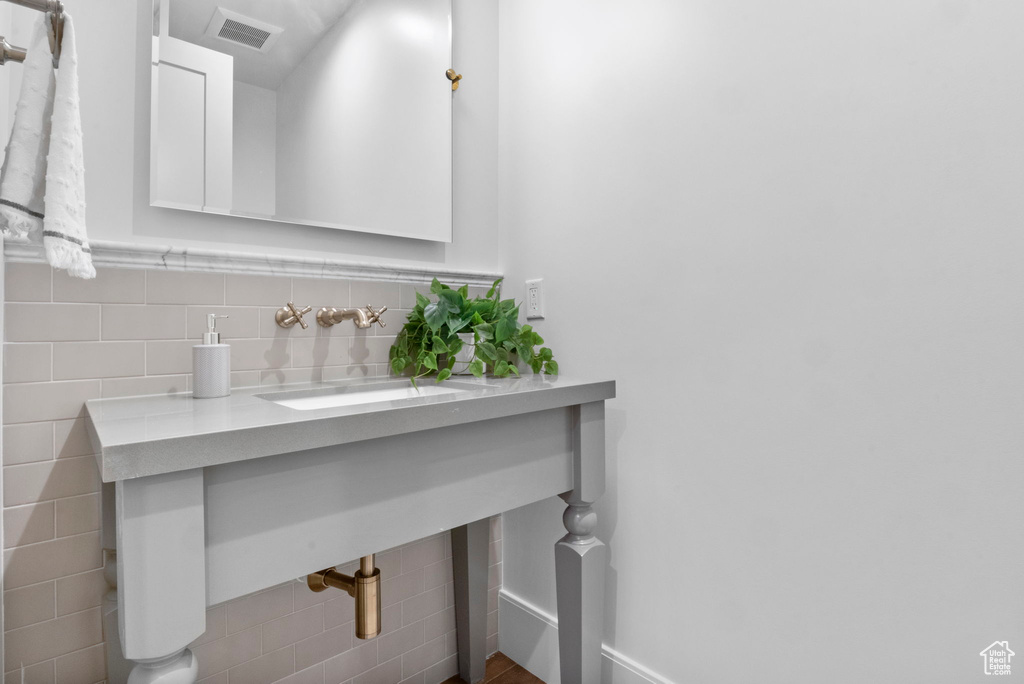 Bathroom with sink and tile walls